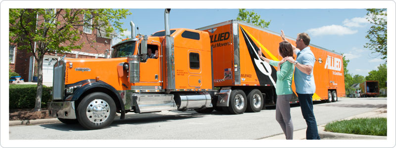 Couple waving to moving truck driver