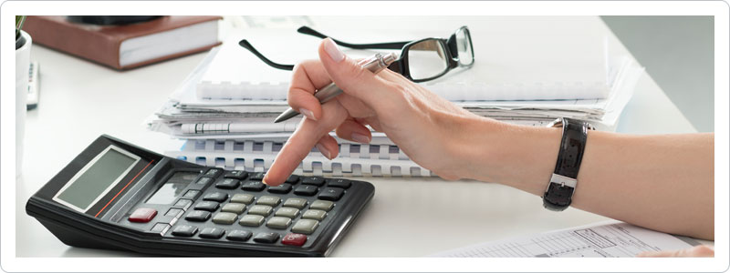 Woman using a calculator while budgeting for moving expenses