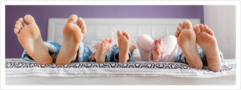 Family lying in bed on the first night in their new home