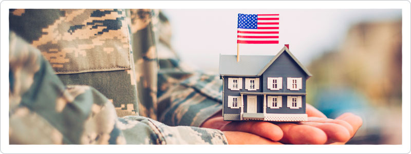 Military personnel holding tiny house