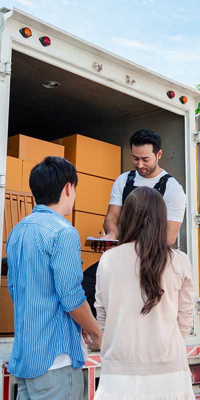 Couple check while unloading boxes and furniture from a truck